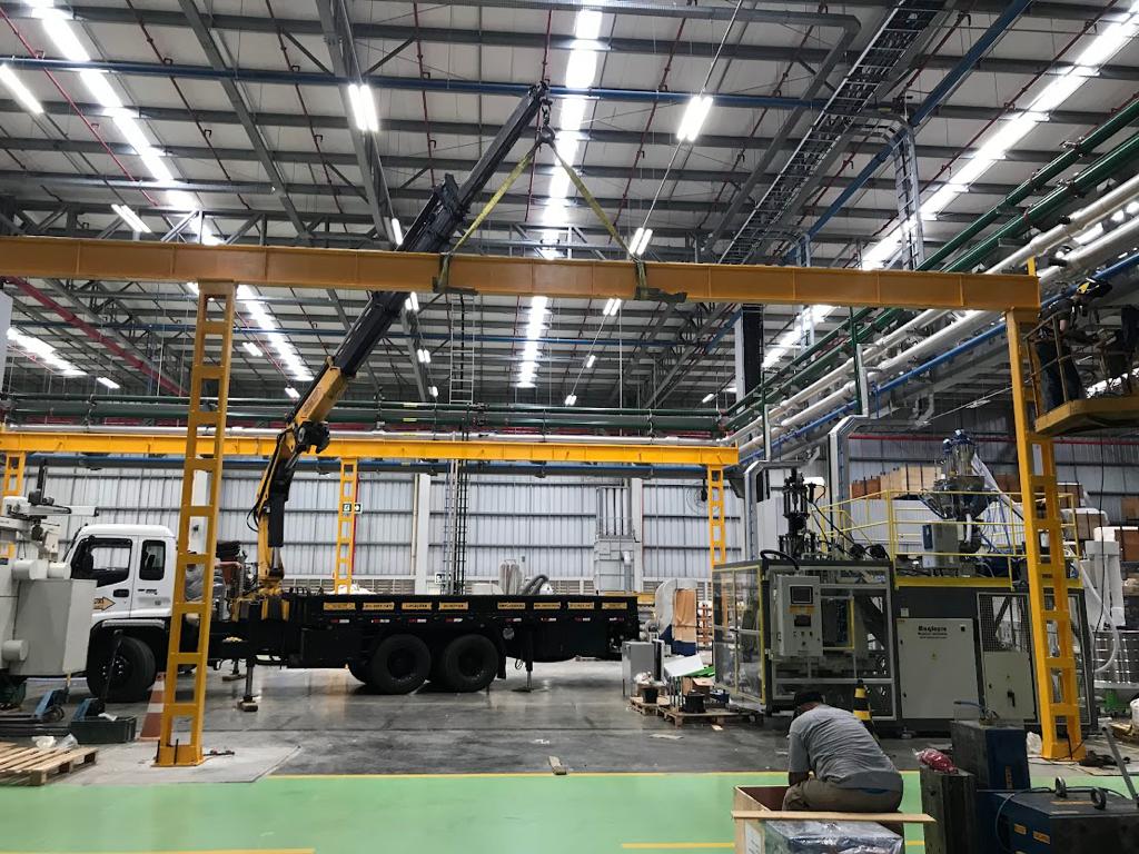 Equipe Astec realizando montagem de ponte rolante em planta industrial moderna